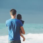 Man holding daughter at the beach in family case