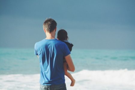 Man holding daughter at the beach in family case